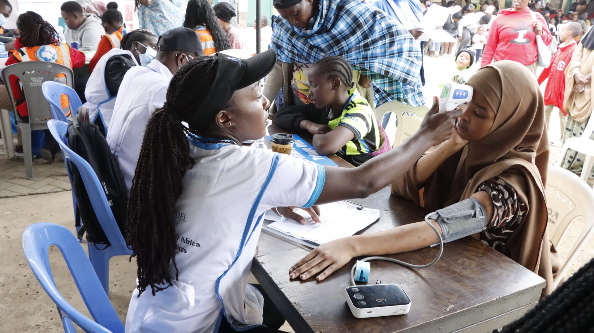 African health workers providing care at a community medical outreach